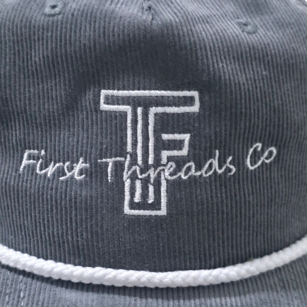 Gray cap with 'First Threads Co' logo and text on a close-up view